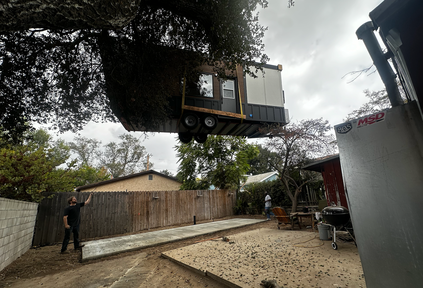 A tiny home being carefully lifted by a crane and placed onto its prepared site, illustrating the importance of meticulous planning in tiny home construction.