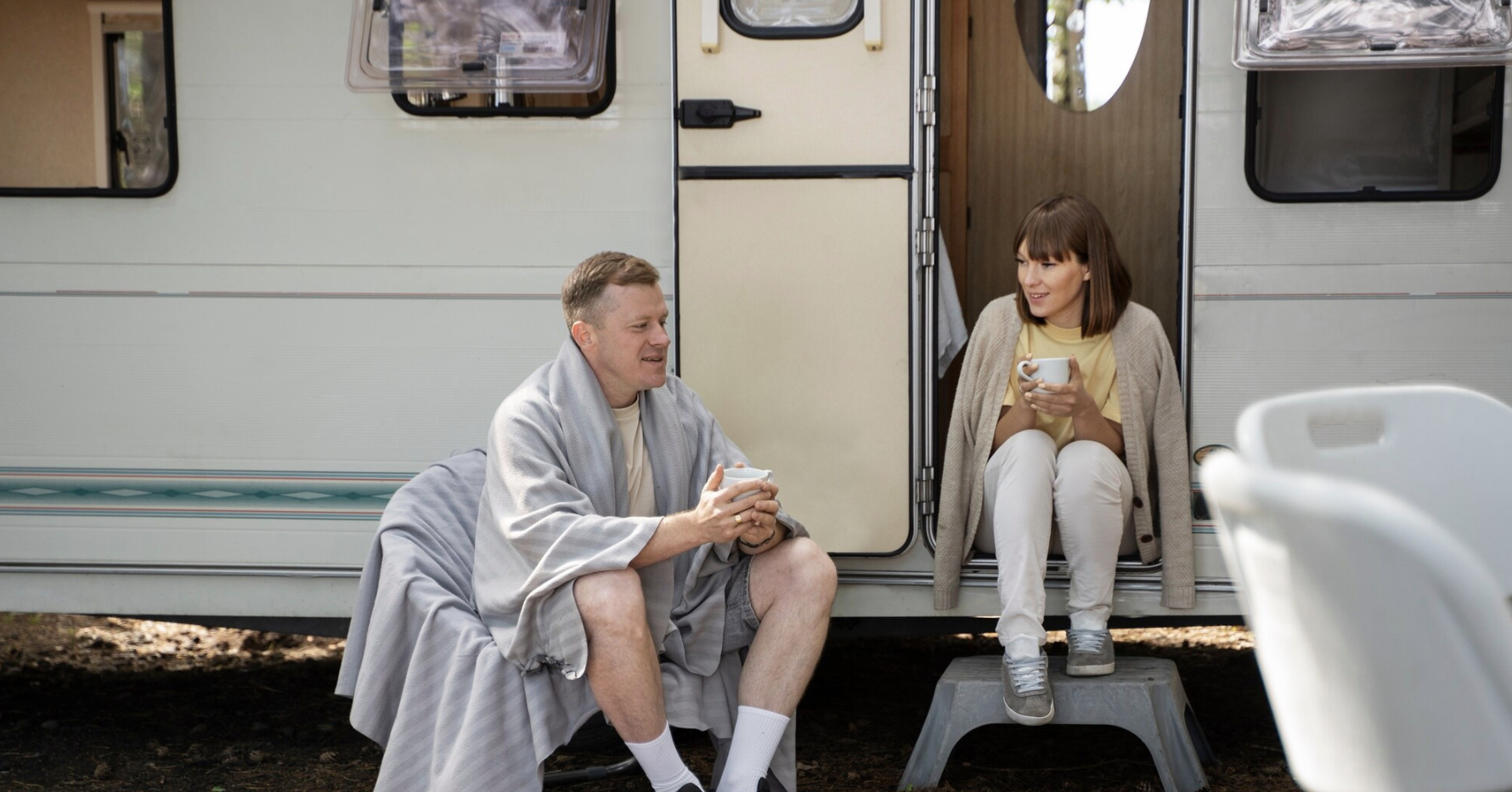 A couple in their tiny house RV enjoying morning sip of coffee
