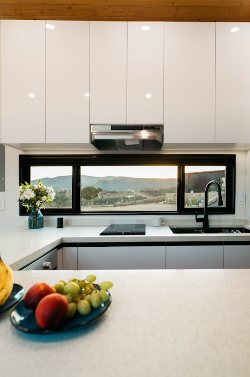Luxury tiny home kitchen with quartz countertop and full cabinetry.