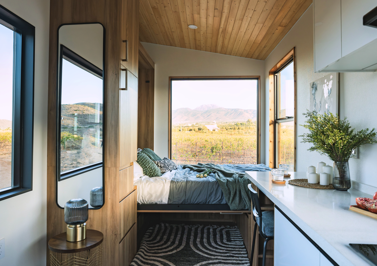 Clever Tiny Home Murphy bed folded down in cozy sleeping nook with integrated storage and convertible workspace.