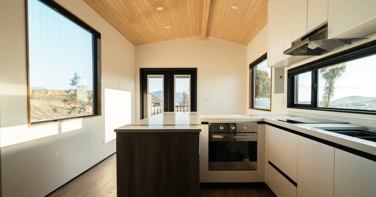 Interior of a modern tiny house on wheels with a full-sized kitchen