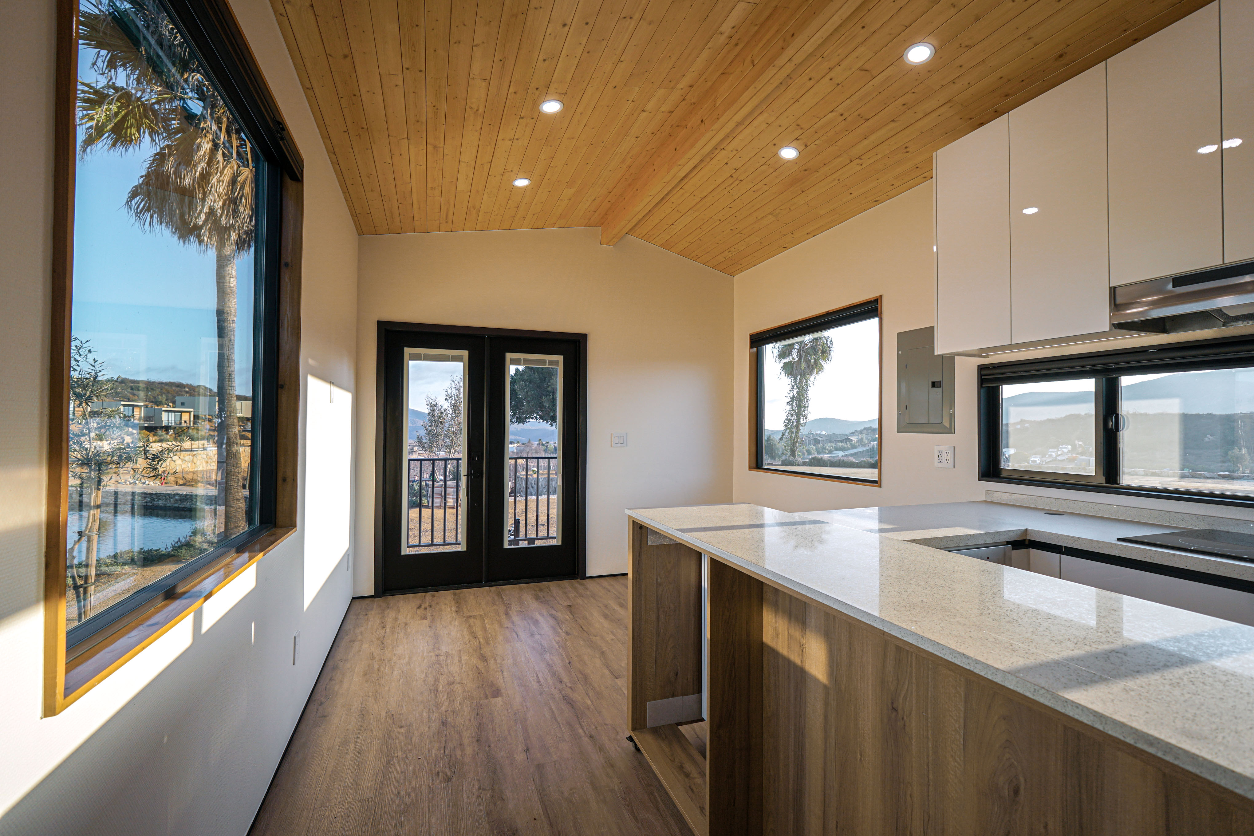 Interior view of a Clever 1 tiny home, featuring a full kitchen with stainless steel appliances, built-in storage, and high-end finishings.