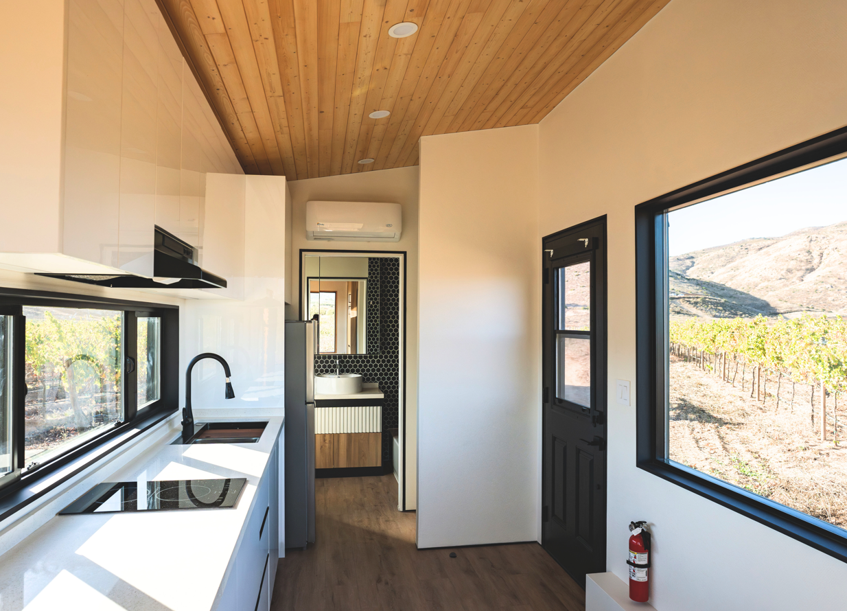 Open living area inside a Clever Tiny Home featuring natural light, wood finishes, and efficient multi-use design.