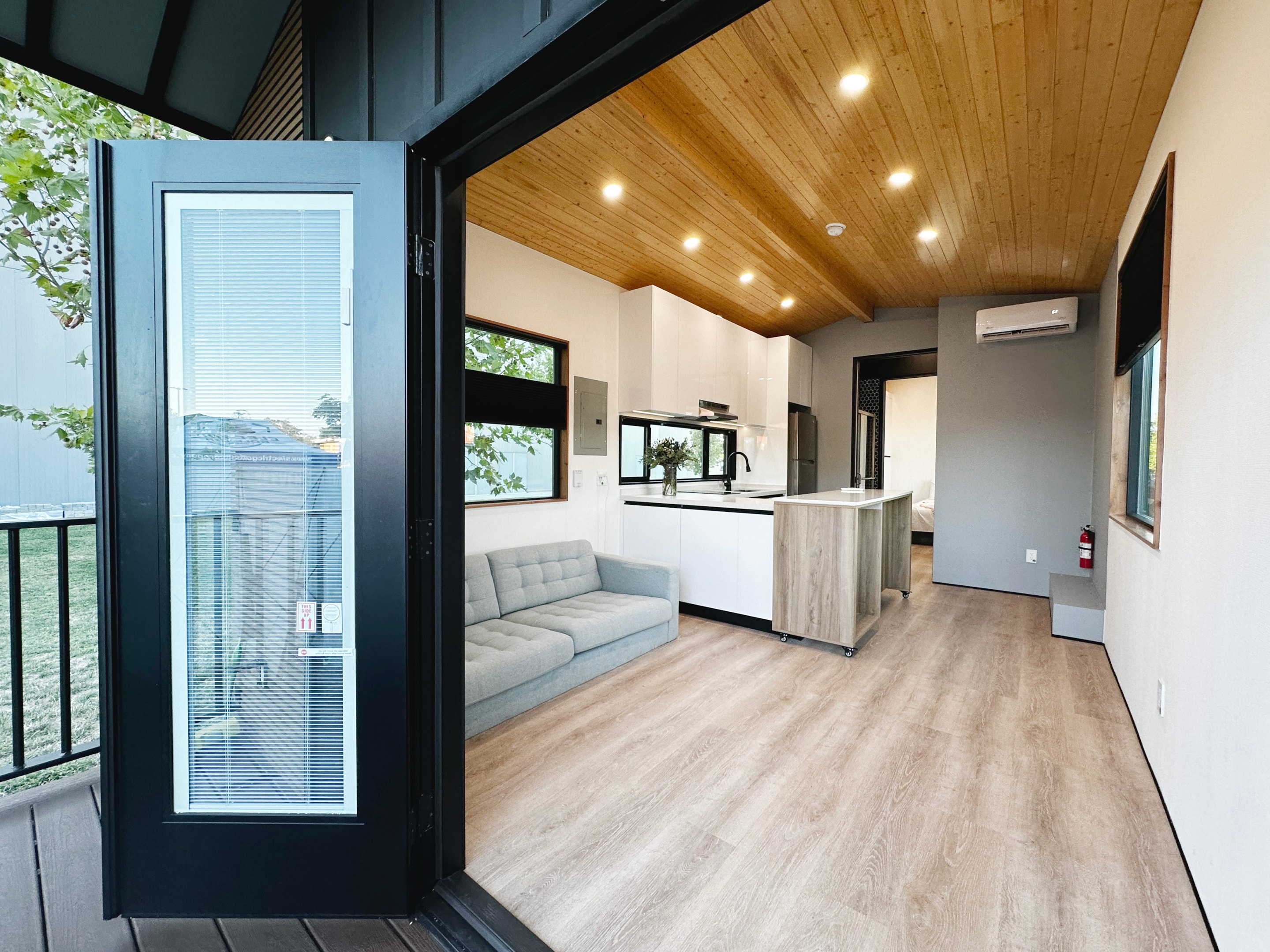 Interior of a modern tiny home with wooden vynil flooring and high-end finishings.