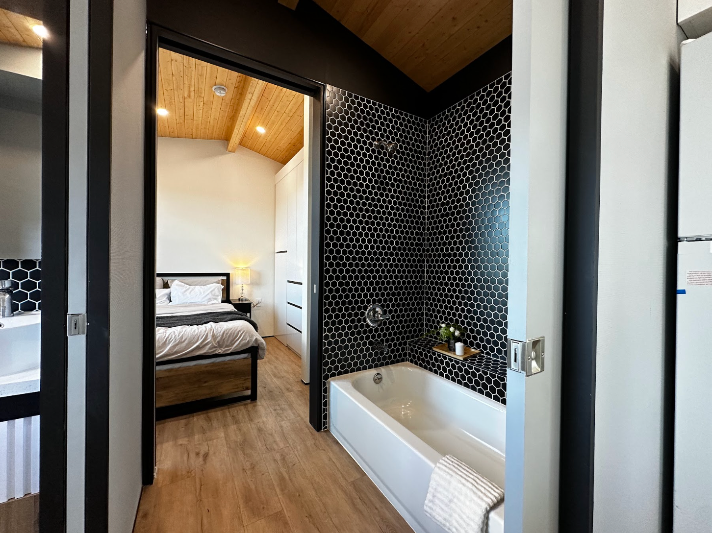 A luxury bathroom in a one-bedroom tiny home, with a bathtub, large vanity and real tiles.