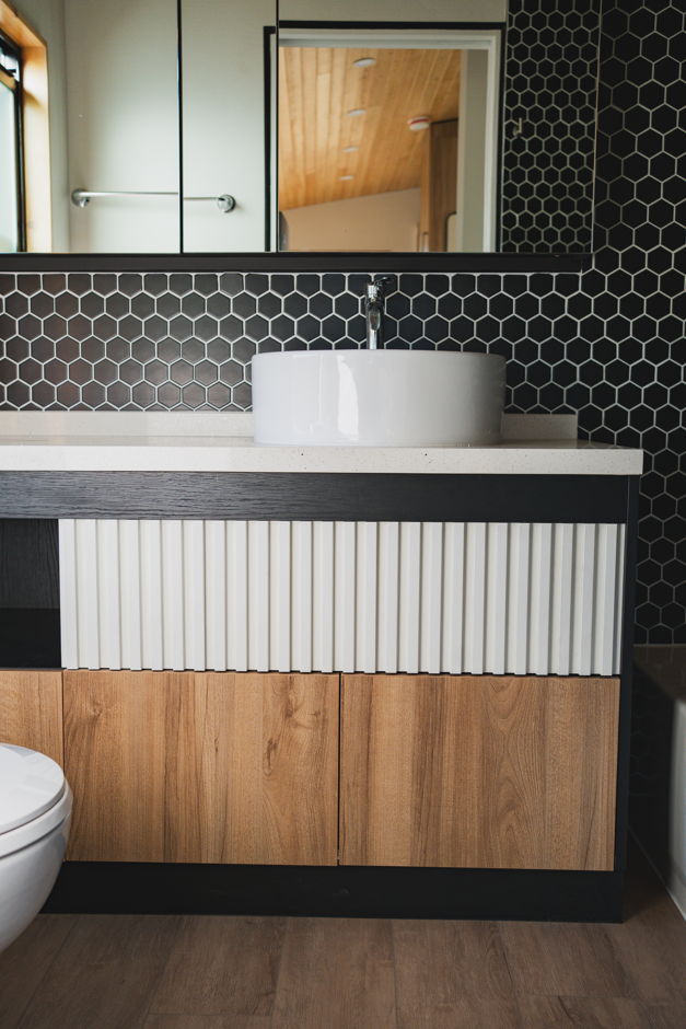 Luxury tiny home bathroom with large mirror and modern vanity.