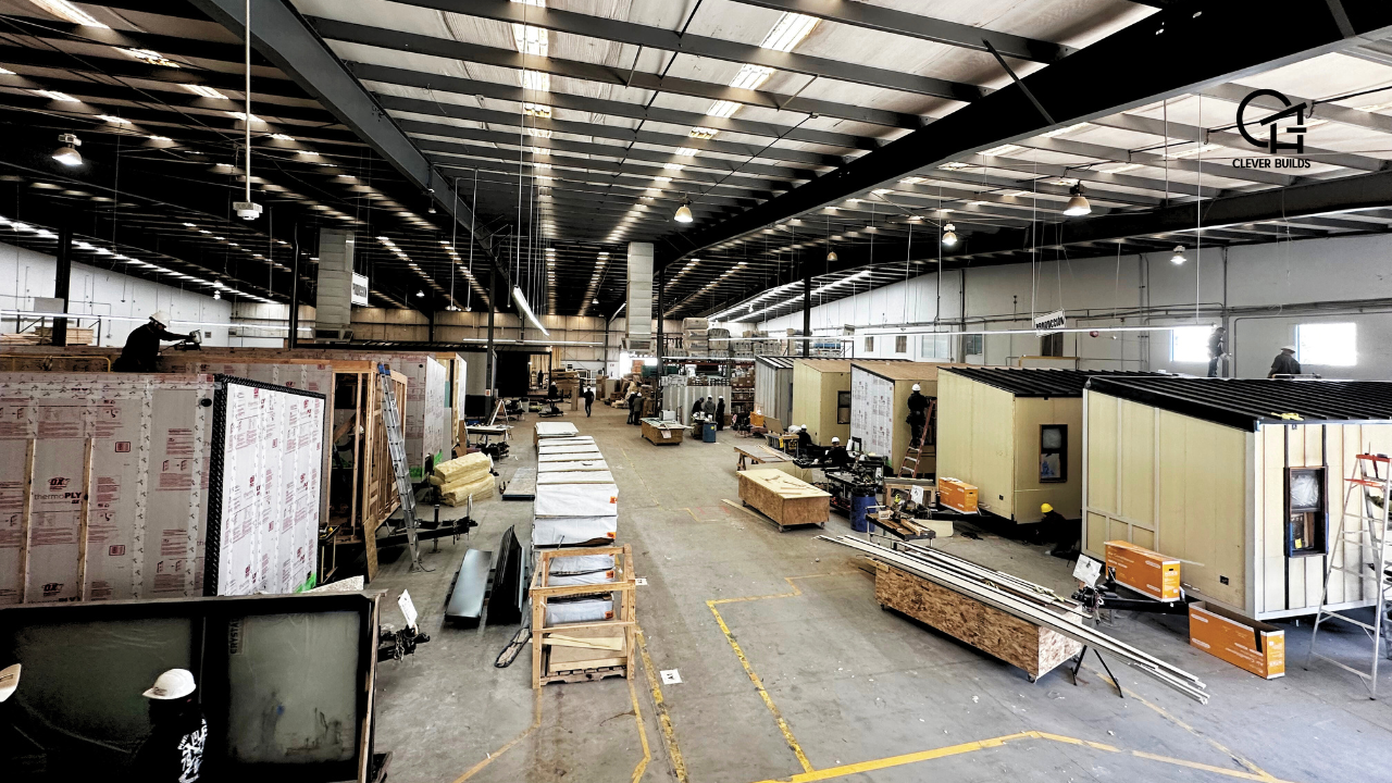 Workers assembling a tiny home at the Clever Tiny Homes factory, focusing on construction details