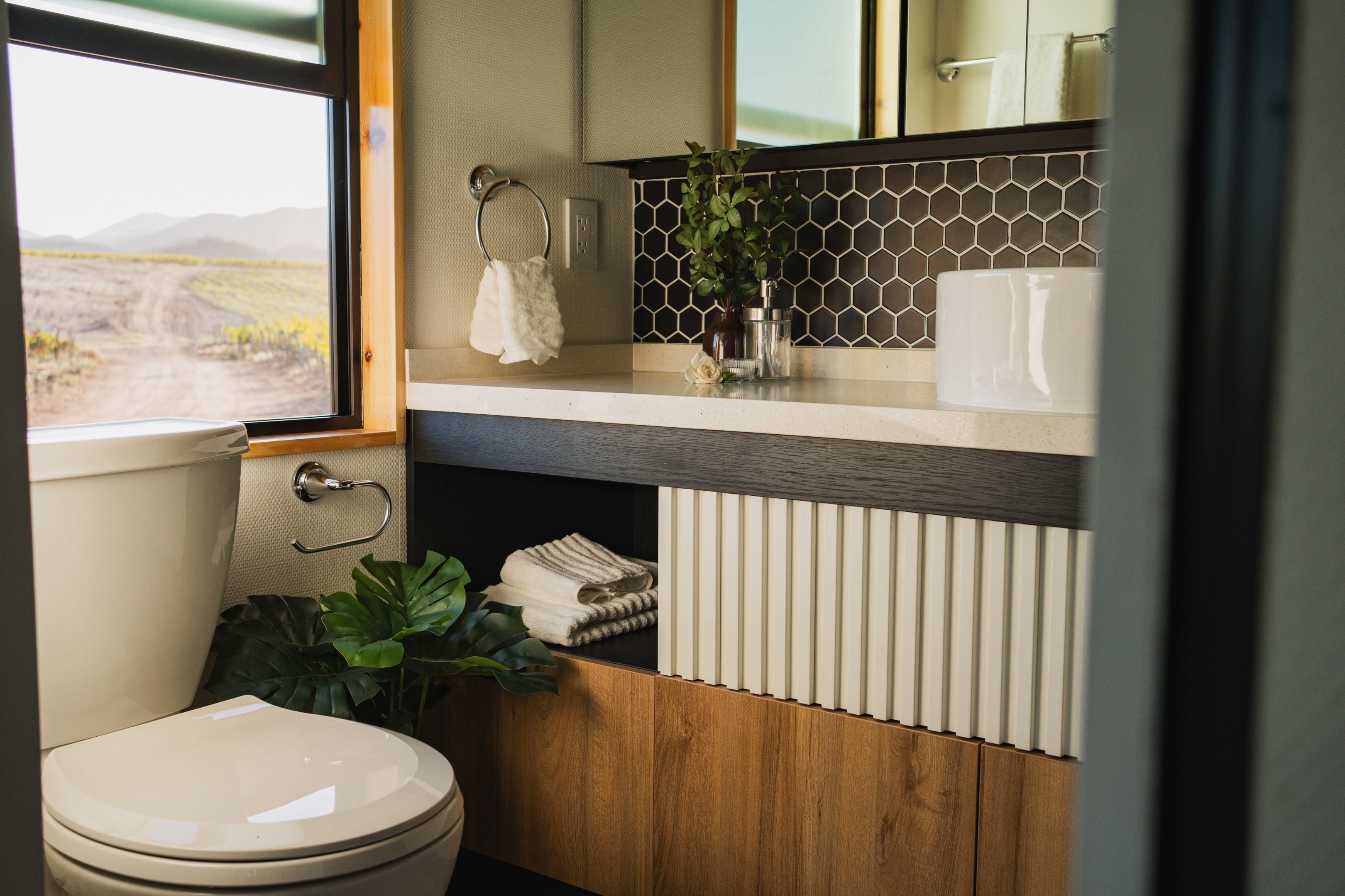 Spa-like bathroom in a high-end tiny home, with real tiles, large vanity and medicine cabinet. 