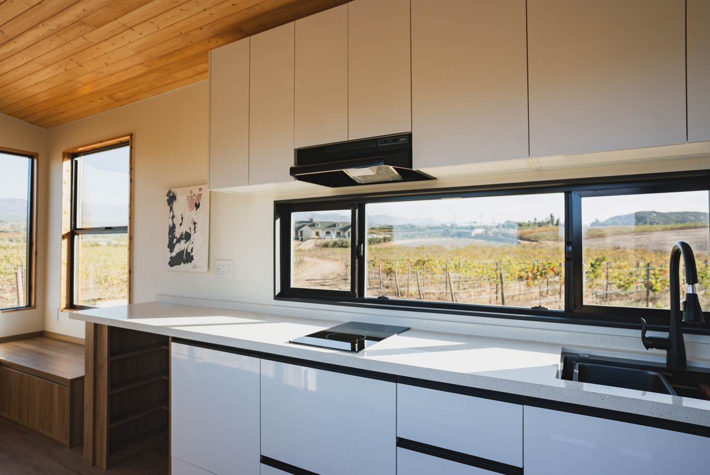 Luxury tiny home kitchen with large quartz countertop and soft-close cabinets.