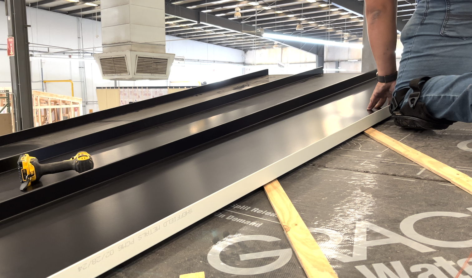 Men working on a standing seam metal roof of a modern tiny home.