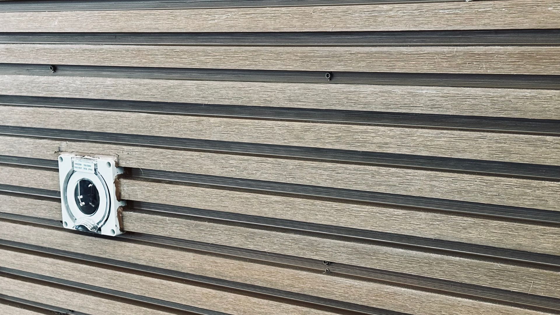 A water hookup outlet on the side of a tiny home.